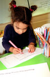 Daisy, 4, colours in pictures in her own copy of The Dog From Darjeeling.